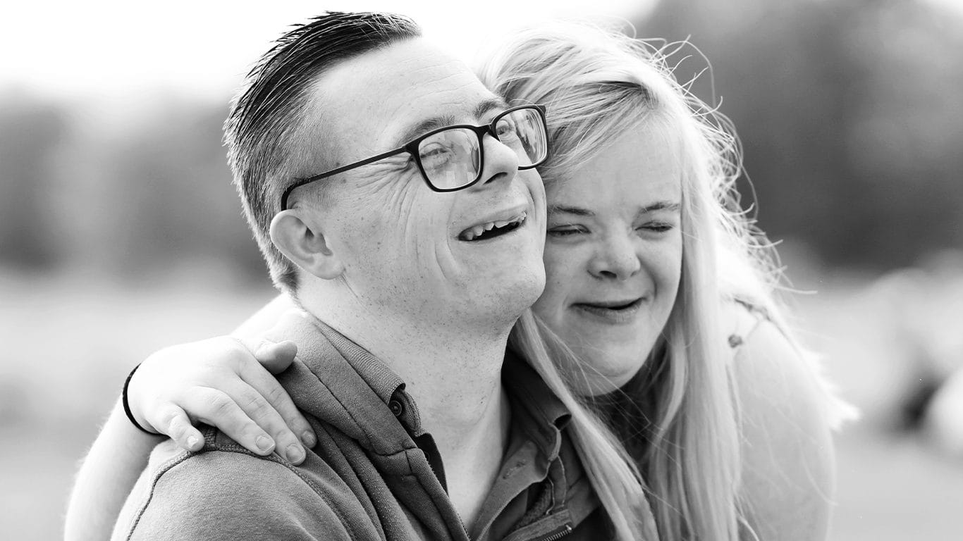 Heidi and James, down syndrome patrons smiling in a happy couple picture together