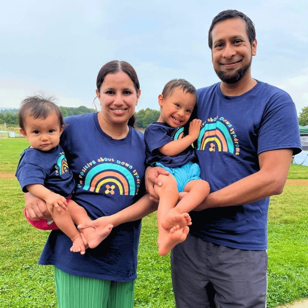 A group photo of a family. Mum and dad are each holding a child.