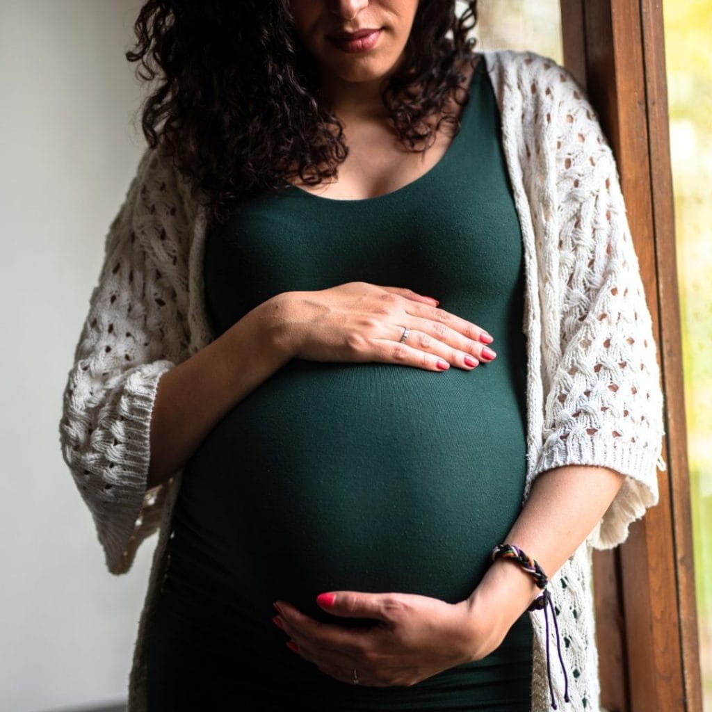 a pregnant women holding her bump with two hands