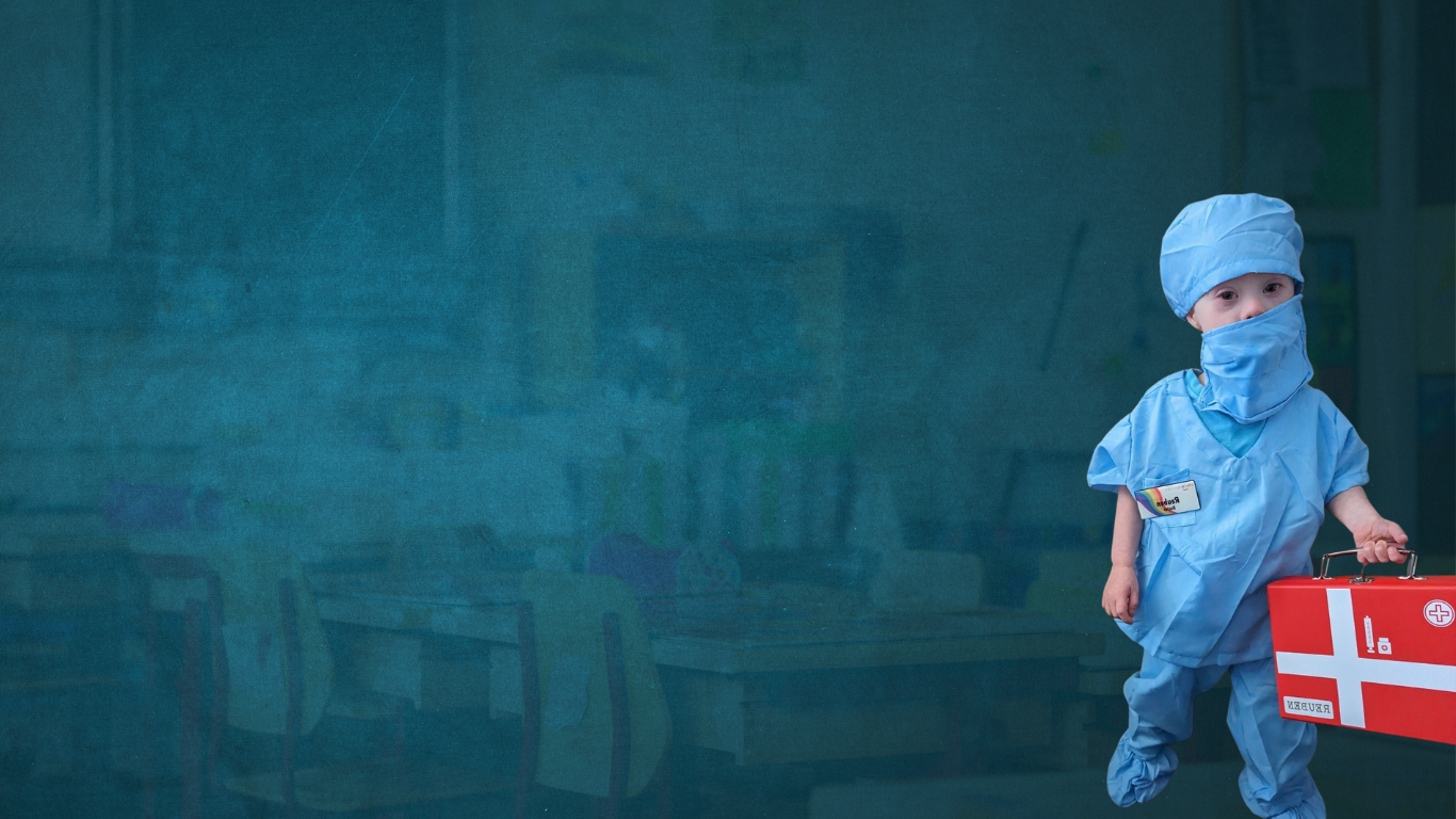 Child dressed up as a doctor with a blue face mask, medical gown and hat, holding a medical briefcase